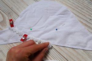 auf die umsäumten Außenkante der Ärmelteile wird eine Spitzenborde mit einem geraden Stich aufgenäht